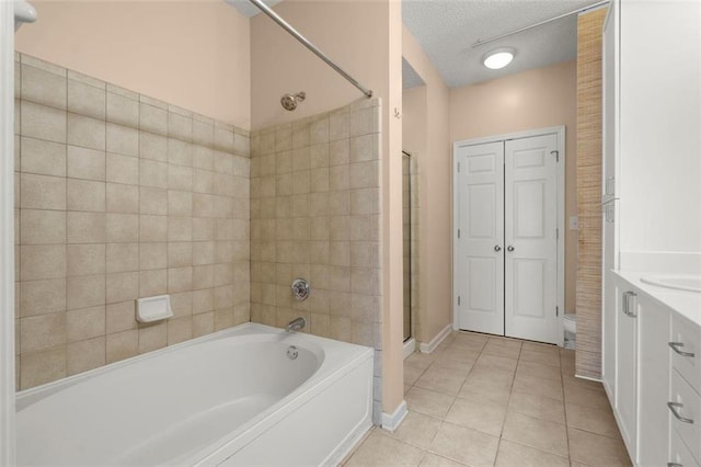 bathroom with a textured ceiling, a garden tub, tile patterned flooring, vanity, and a stall shower