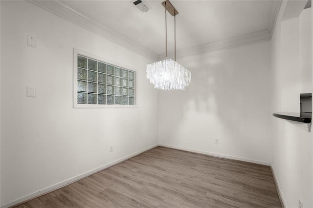 unfurnished dining area with baseboards, visible vents, ornamental molding, wood finished floors, and a chandelier