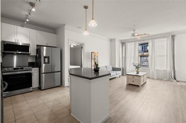 kitchen featuring dark countertops, a textured ceiling, appliances with stainless steel finishes, and a ceiling fan