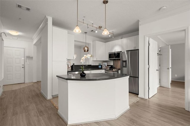 kitchen featuring visible vents, white cabinets, dark countertops, appliances with stainless steel finishes, and crown molding