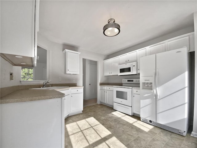 kitchen with sink, white appliances, and white cabinets