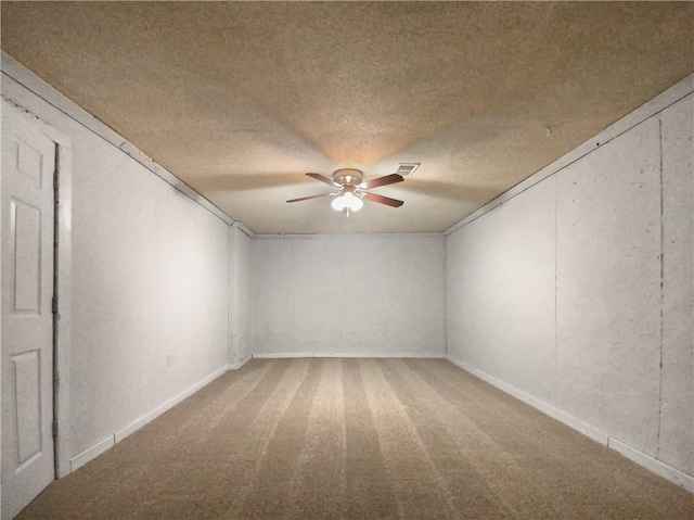 unfurnished room with a textured ceiling, carpet flooring, and ceiling fan