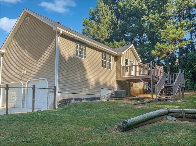 rear view of house with a lawn, a garage, and a deck