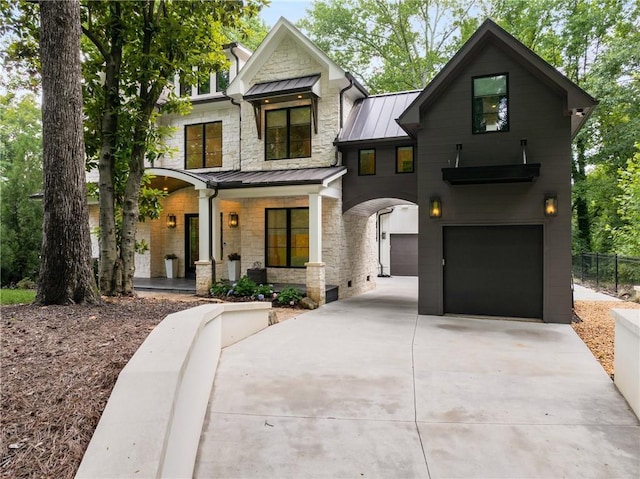 306 Pinecrest Rd NE, Atlanta, GA 30342 - view of front of property with a standing seam roof, covered porch, concrete driveway, a garage, and stone siding