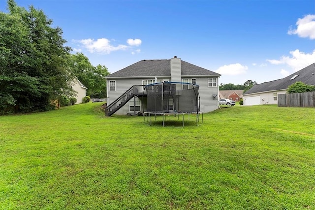 3625 Wapakonata Trl, Bethlehem, GA 30620 - back of house with stairway, a chimney, a lawn, and a trampoline