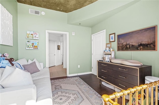 interior space featuring dark wood-type flooring, baseboards, and visible vents