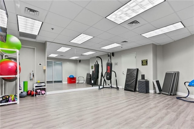 workout area featuring visible vents, baseboards, and wood finished floors