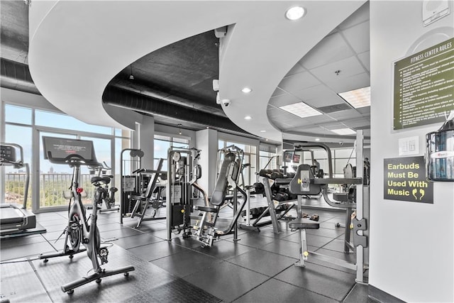 exercise room with recessed lighting, expansive windows, and a paneled ceiling