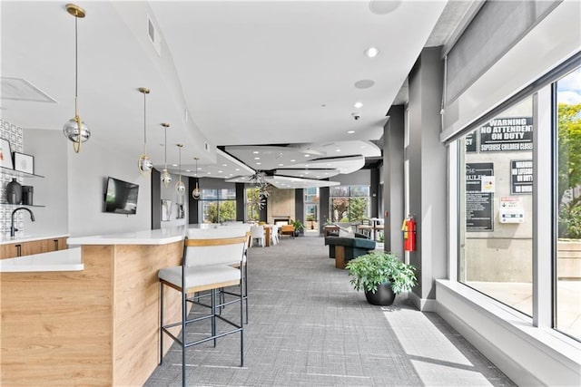 interior space with recessed lighting, a sink, light countertops, decorative light fixtures, and carpet flooring