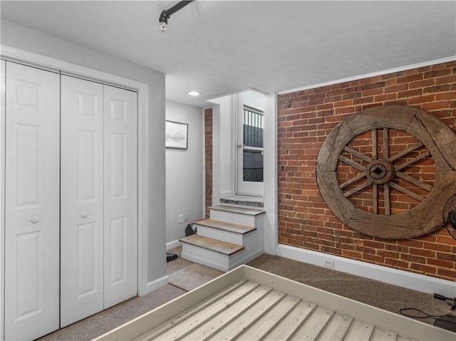 interior space with brick wall and baseboards