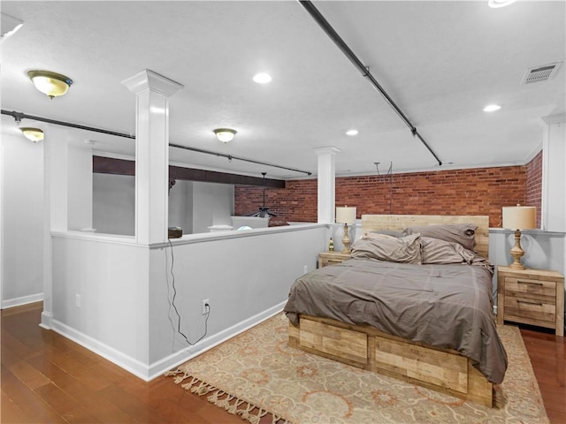 bedroom featuring recessed lighting, brick wall, wood finished floors, visible vents, and baseboards