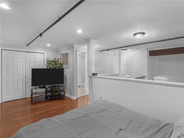 bedroom featuring ornamental molding, a closet, wood finished floors, and recessed lighting