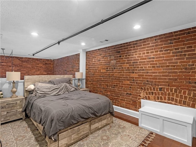 bedroom featuring visible vents, brick wall, a textured ceiling, light wood-style floors, and recessed lighting