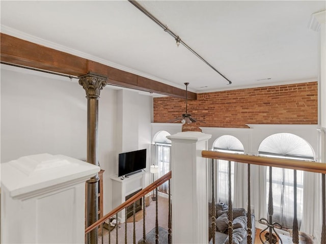 corridor with brick wall and an upstairs landing