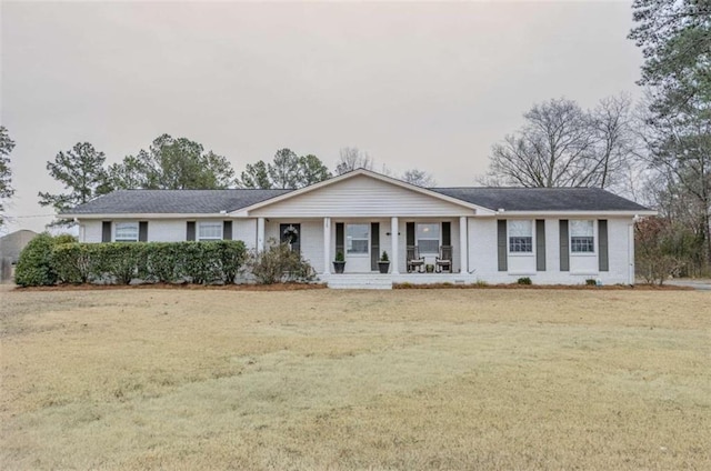 ranch-style house with covered porch and a front yard