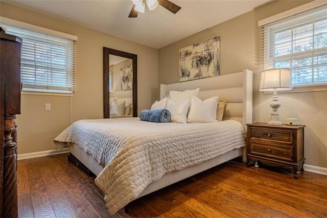 bedroom with ceiling fan, dark wood-type flooring, and multiple windows