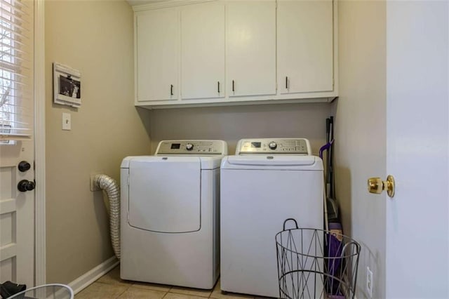 laundry area with washer and clothes dryer, light tile patterned floors, and cabinets