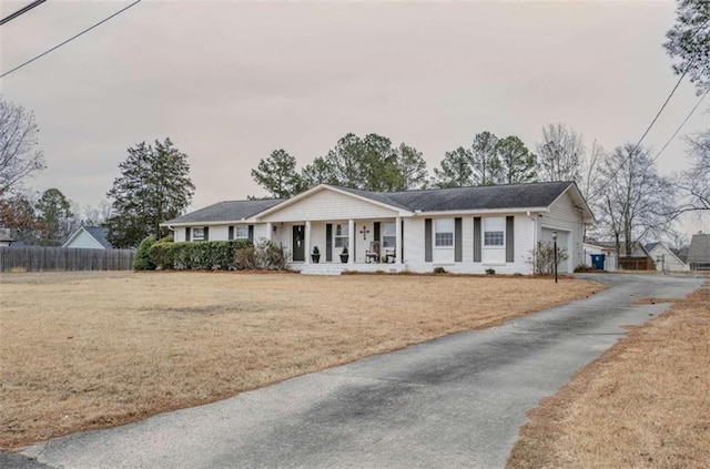 single story home featuring covered porch, a garage, and a front lawn