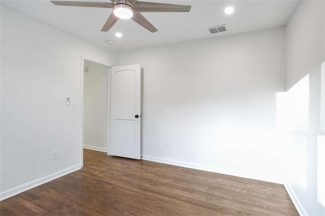 empty room featuring dark wood-type flooring and ceiling fan