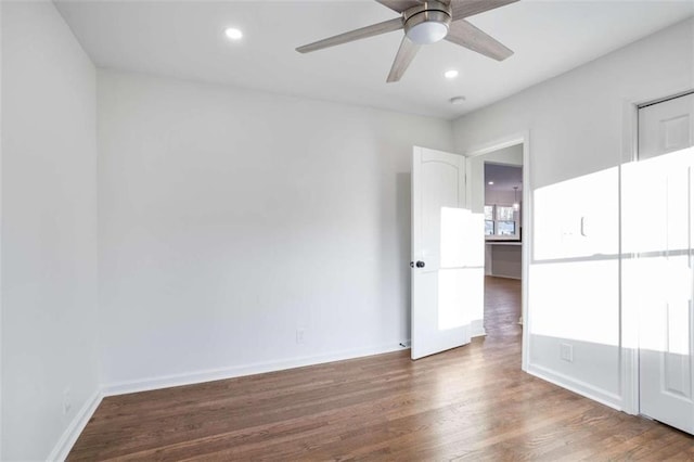 spare room with dark wood-type flooring and ceiling fan