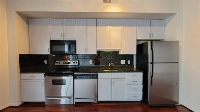 620 Glen Iris Dr NE Unit 321, Atlanta, GA 30308 - kitchen with appliances with stainless steel finishes, white cabinetry, tasteful backsplash, dark wood finished floors, and dark stone countertops