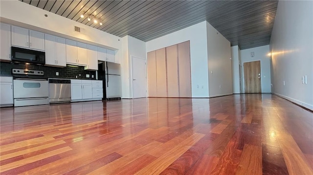 620 Glen Iris Dr NE Unit 321, Atlanta, GA 30308 - kitchen featuring electric range oven, freestanding refrigerator, stainless steel dishwasher, black microwave, and white cabinets