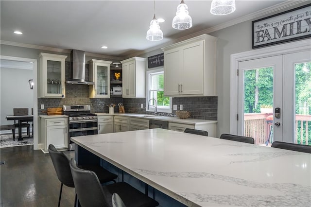 4569 Campenille Trce, Suwanee, GA 30024 - kitchen featuring wall chimney range hood, appliances with stainless steel finishes, crown molding, a breakfast bar area, and hanging light fixtures