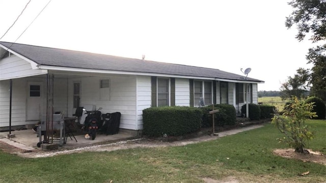 back of house with a lawn and a patio area