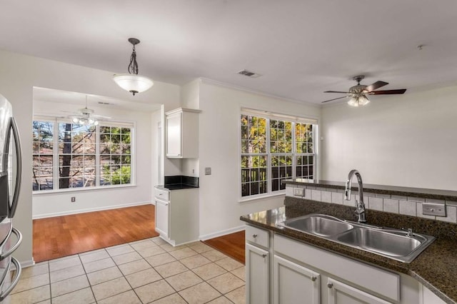 kitchen featuring decorative light fixtures, sink, ceiling fan, light tile patterned floors, and white cabinets