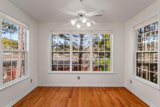 unfurnished dining area with hardwood / wood-style floors and ceiling fan