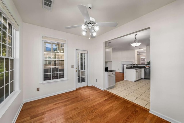 interior space with light hardwood / wood-style floors, sink, and ceiling fan