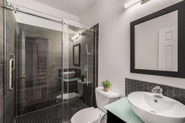 bathroom featuring toilet, vanity, an enclosed shower, and tasteful backsplash