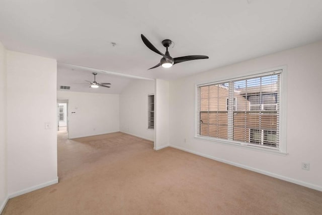 unfurnished room with vaulted ceiling, light colored carpet, and ceiling fan