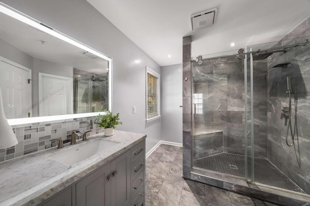 bathroom with vanity, backsplash, and walk in shower