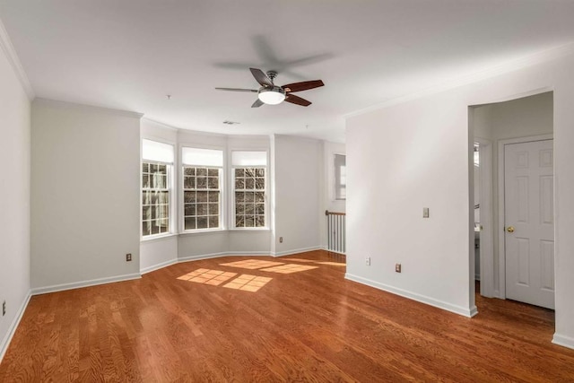 unfurnished room featuring hardwood / wood-style floors, ceiling fan, and crown molding