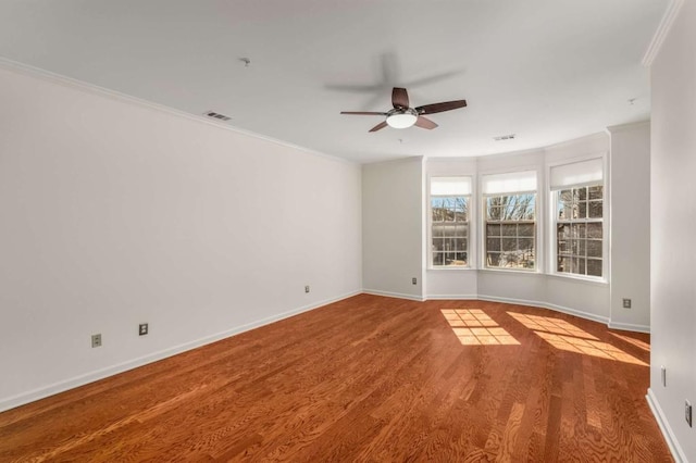 unfurnished room featuring ceiling fan, wood-type flooring, and ornamental molding