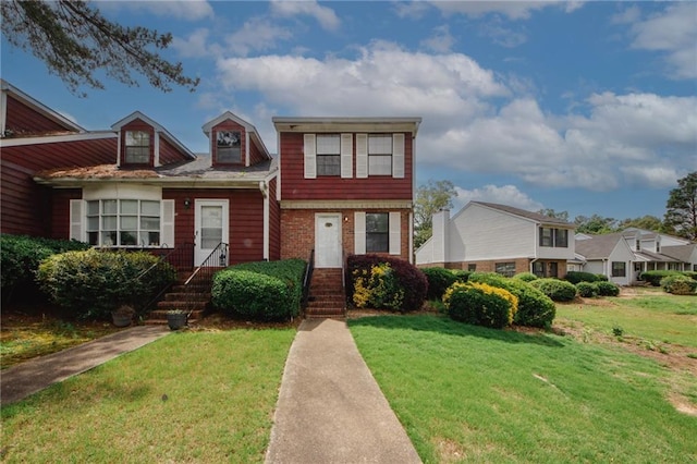 view of front facade with a front yard and brick siding