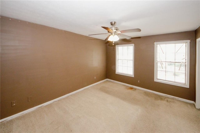 unfurnished room with baseboards, light carpet, and a ceiling fan