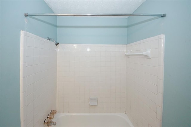 full bathroom featuring  shower combination and a textured ceiling