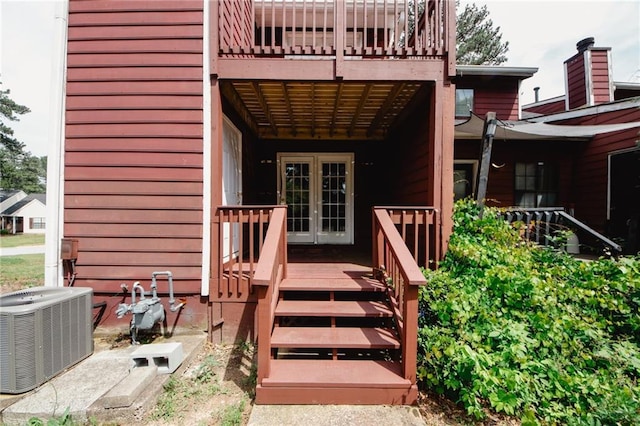 view of exterior entry featuring cooling unit, french doors, and a wooden deck
