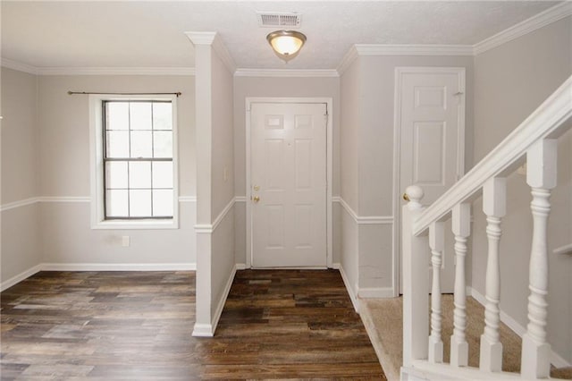 foyer entrance with wood finished floors, baseboards, ornamental molding, and stairway