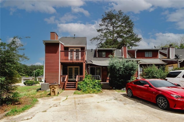 multi unit property with a chimney, french doors, central AC unit, and a balcony