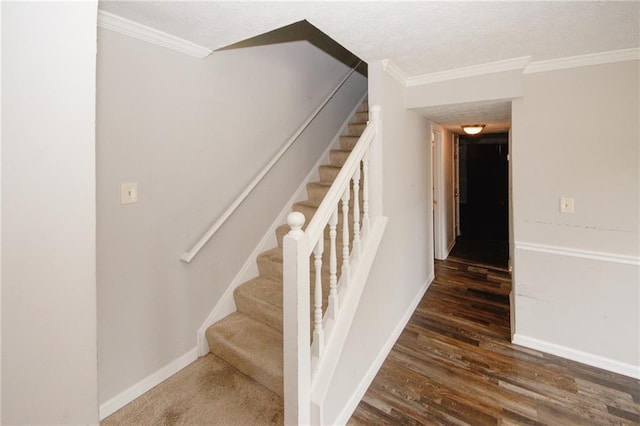 stairs with wood finished floors, baseboards, and ornamental molding