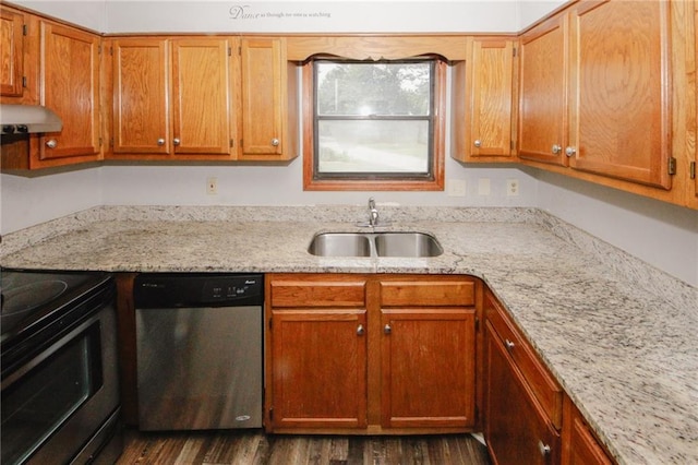kitchen with stainless steel appliances, a sink, dark wood-type flooring, light stone countertops, and brown cabinetry