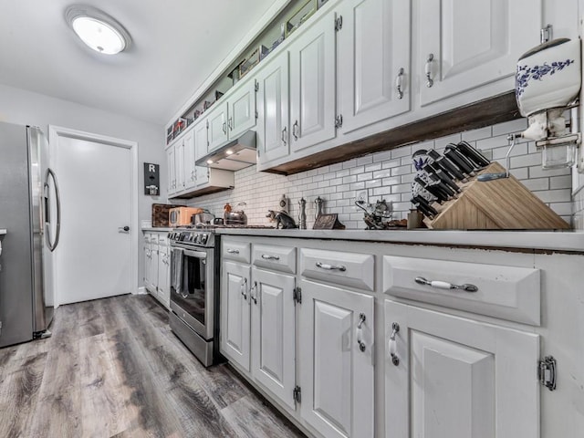 464 Mason Dr, Canton, GA 30115 - kitchen with under cabinet range hood, appliances with stainless steel finishes, backsplash, white cabinetry, and wood finished floors
