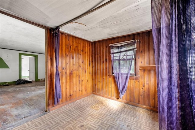 empty room featuring wooden walls and light parquet floors