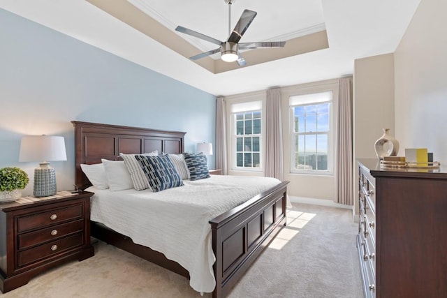 bedroom with a tray ceiling, light carpet, baseboards, and ceiling fan