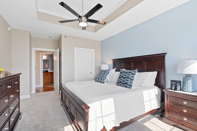 bedroom featuring a raised ceiling, light colored carpet, a ceiling fan, and baseboards