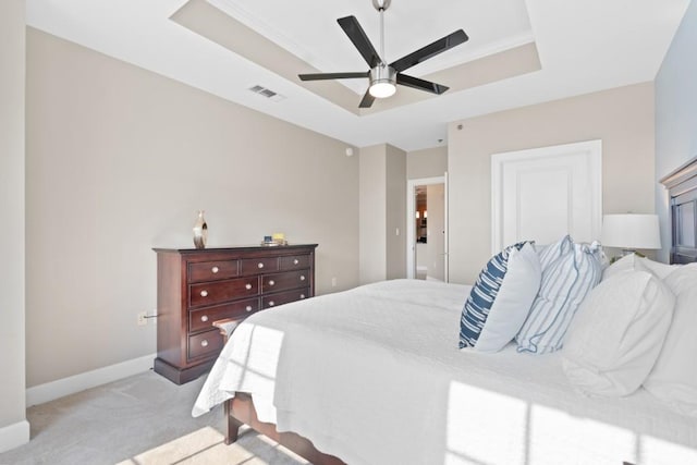 bedroom featuring a tray ceiling, light colored carpet, baseboards, and ceiling fan