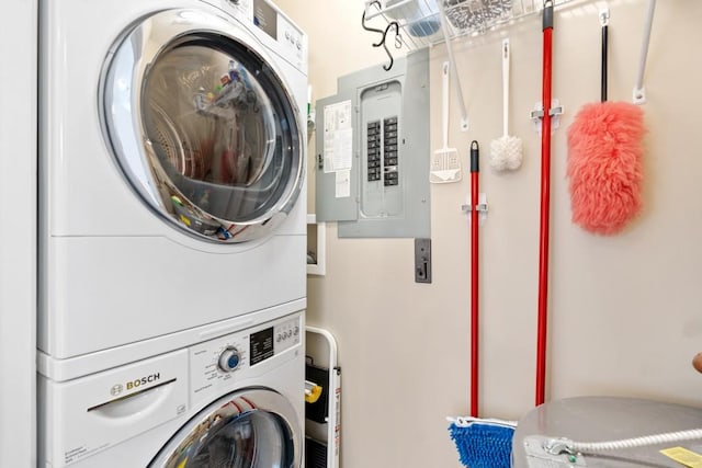 laundry area with stacked washer / drying machine and electric panel